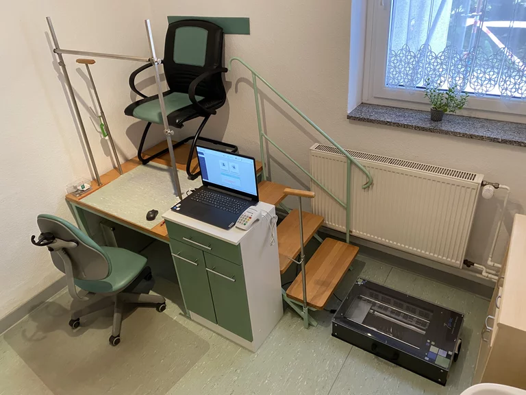 Foto des Messraums: Im Bild sind ein Schreibtischstuhl, verschiedene Messgeräte, ein Computer sowie ein Podest mit drei Stufen zu erkennen.