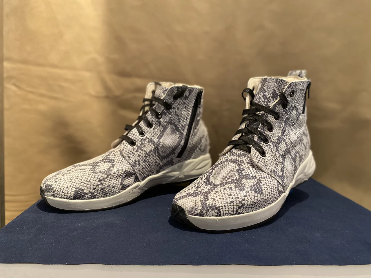 Abgebildet ist ein individuell hergestelltes Paar Schuhe mit weißen Farbelementen.