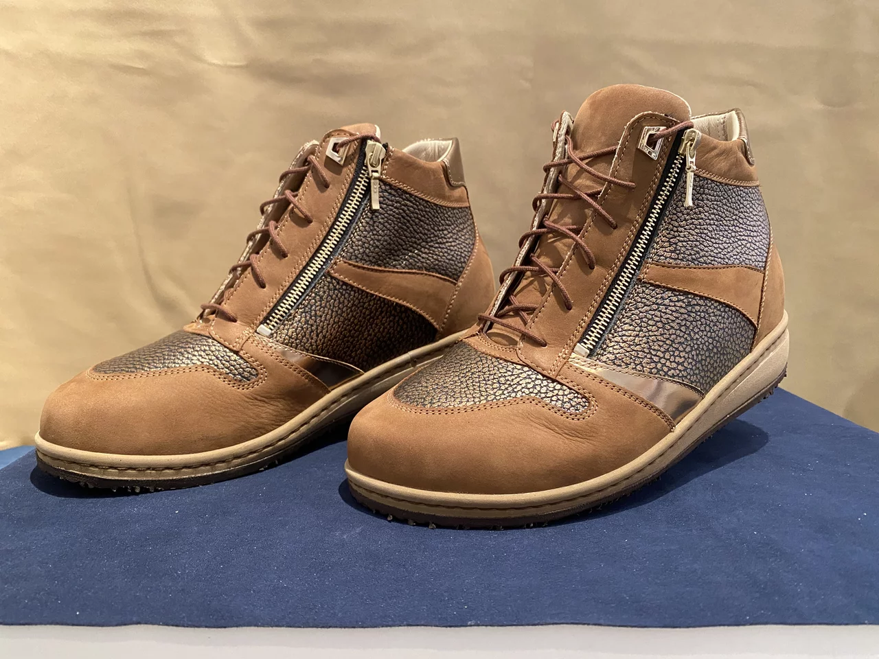 Abgebildet ist ein individuell hergestelltes Paar Schuhe mit braunen Farbelementen.