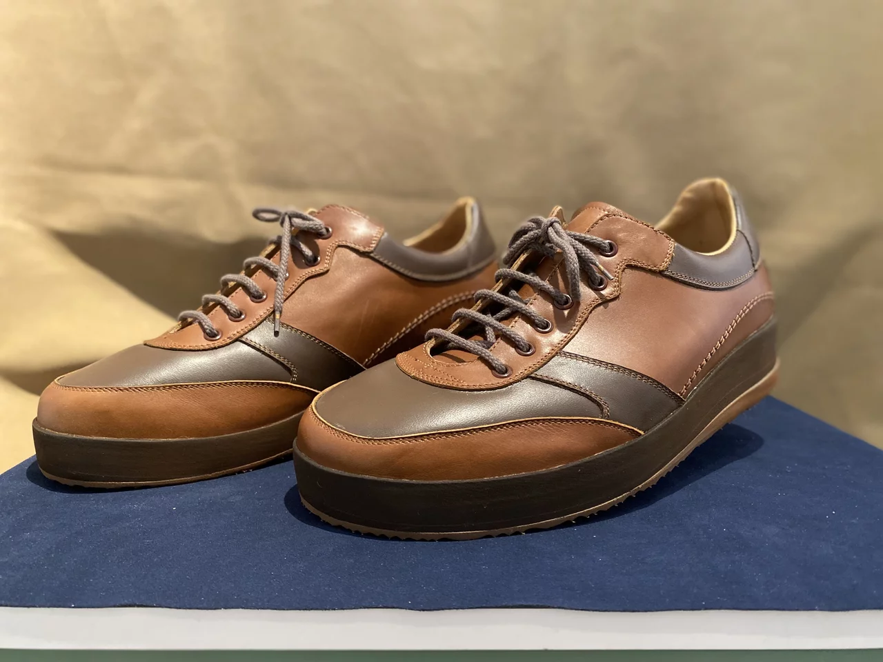 Abgebildet ist ein individuell hergestelltes Paar Schuhe mit braunen Farbelementen.